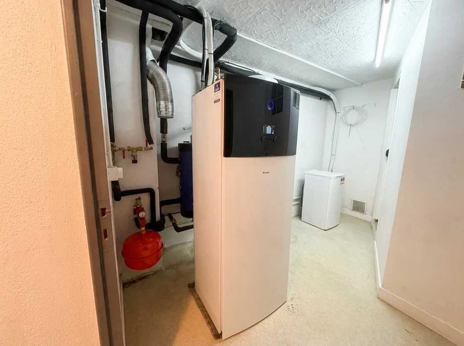 Local technique intérieur avec une pompe à chaleur air/eau Daikin Altherma 3, unité intérieure monobloc blanche avec interface tactile noire