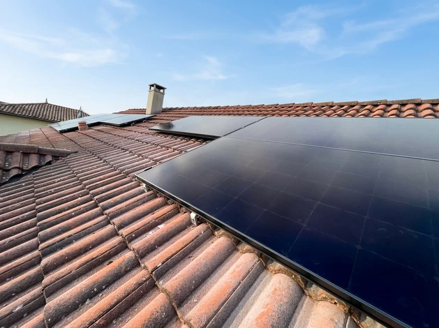 Scène extérieure ensoleillée avec installation photovoltaïque domestique dans un jardin résidentiel verdoyant