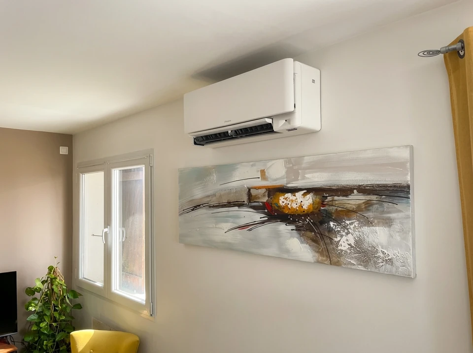 Intérieur résidentiel avec climatiseur mural blanc installé en hauteur sur mur beige
