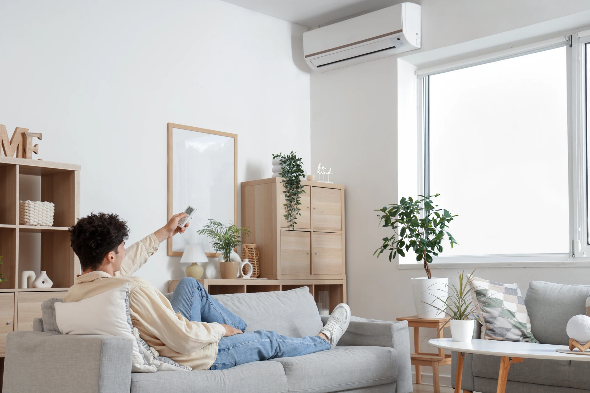 Intérieur résidentiel avec climatiseur mural blanc installé en hauteur sur mur beige